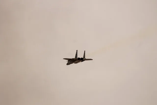 An F-15C Eagle in flight against an orange sky