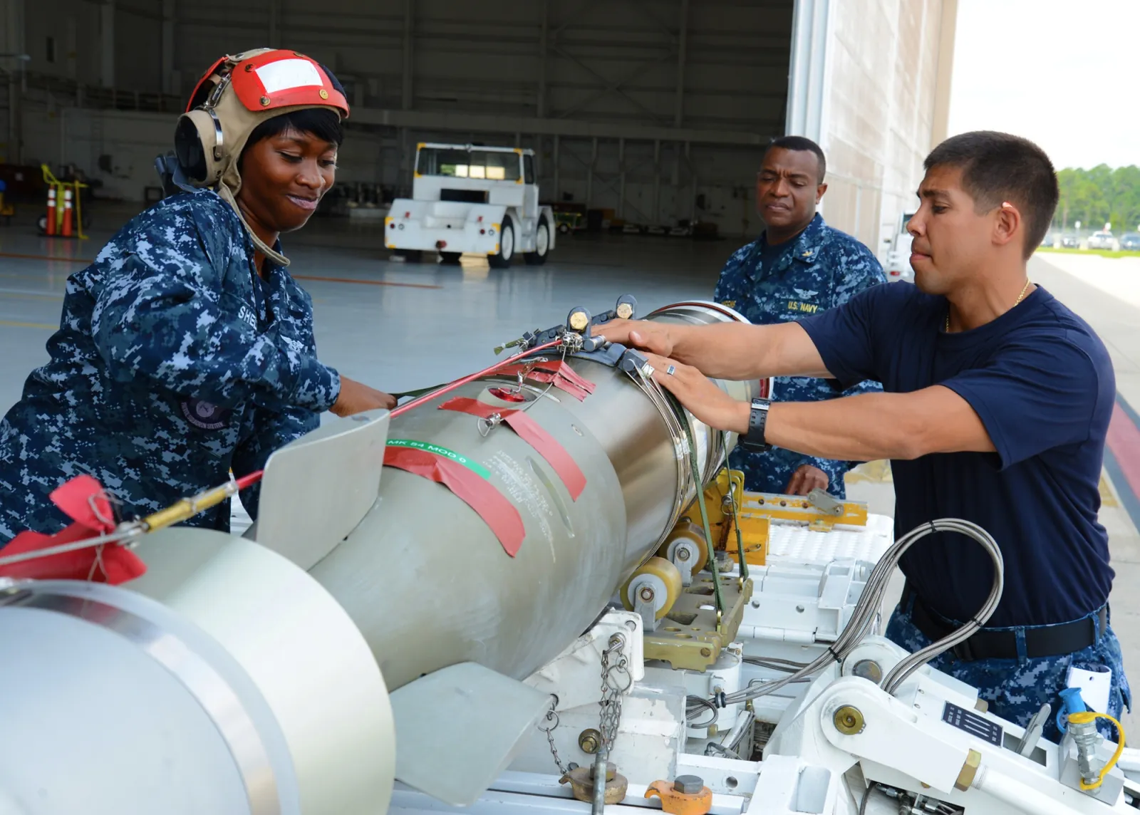 U.S. Navy aircrew prepare an MK-54 lightweight torpedo for loading.