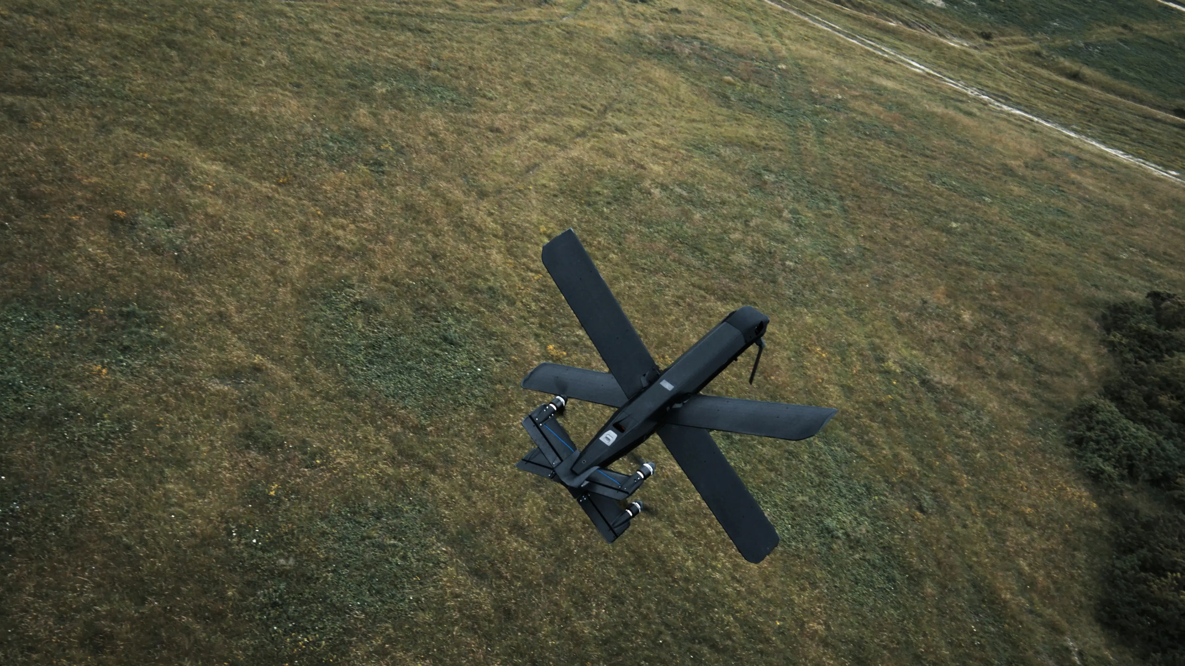 A Helsing HX-2 strike drone in flight above a field