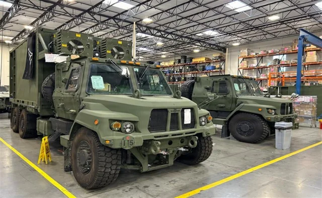 TITAN tactical intelligence vehicles with equipment shelters inside a warehouse
