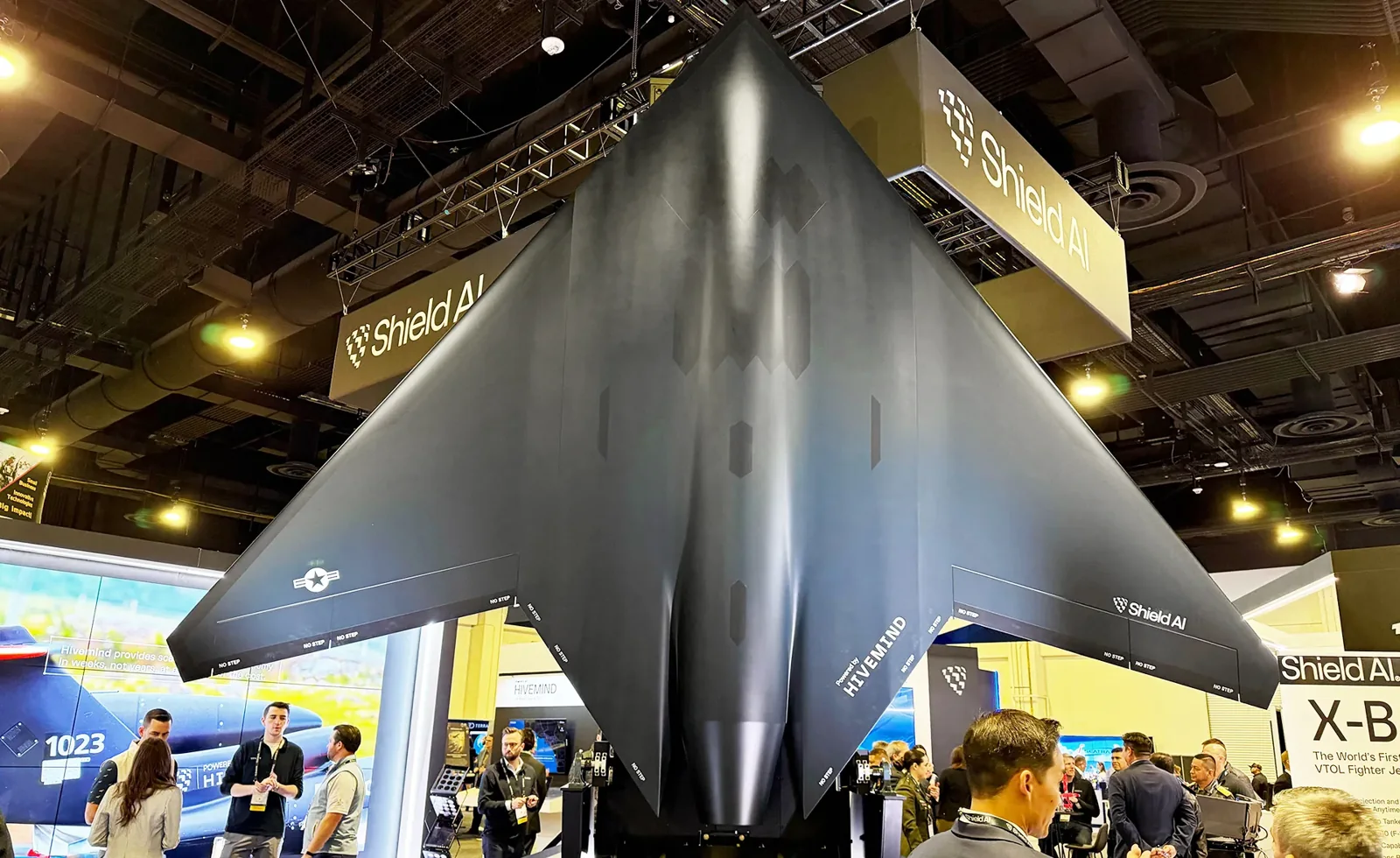Shield AI X-BAT display model mounted vertically at an exhibition booth.