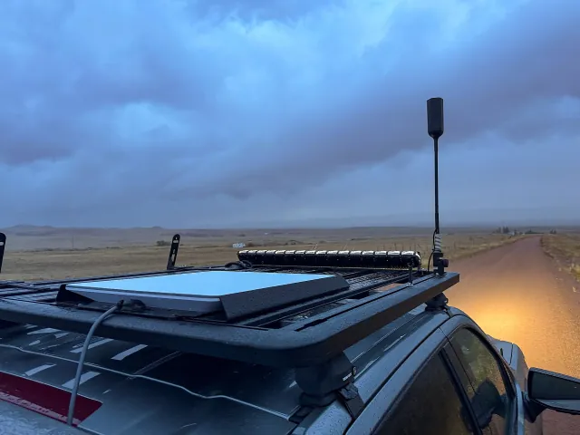 A Starlink flat-panel user terminal mounted on a truck roof rack