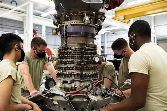 Airmen adjusting a TF34 engine compressor assembly for the A-10C at Moody Air Force Base