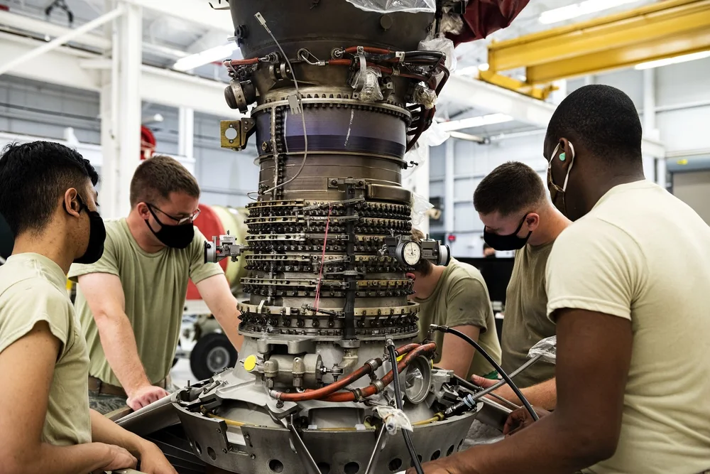 Airmen adjusting a TF34 engine compressor assembly for the A-10C at Moody Air Force Base