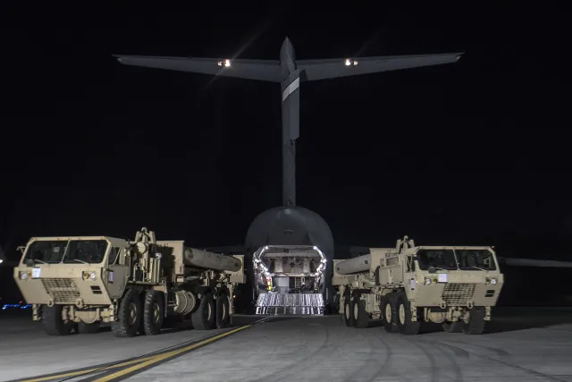 Two THAAD launchers parked in front of a C-17 after arriving in South Korea