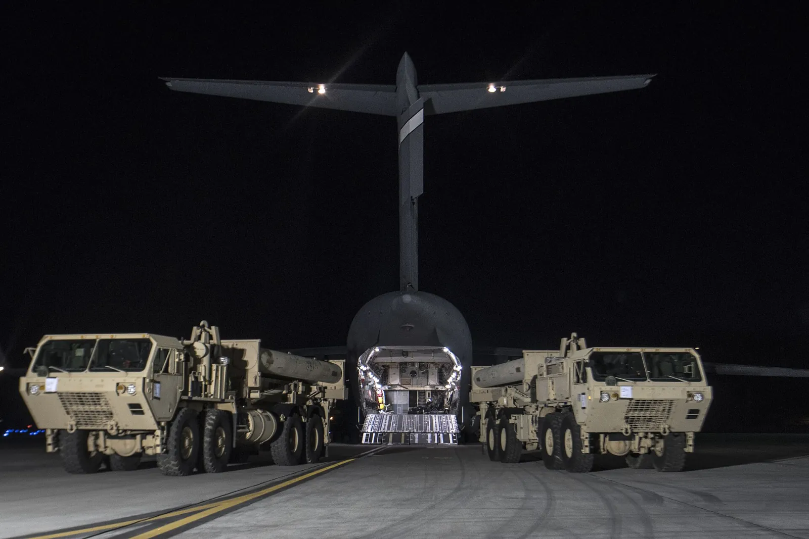 Two THAAD launchers parked in front of a C-17 after arriving in South Korea