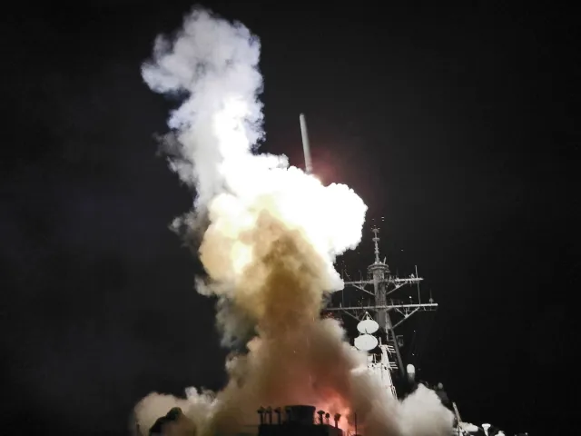Destroyer USS Barry (DDG 52) launching a Tomahawk cruise missile at night